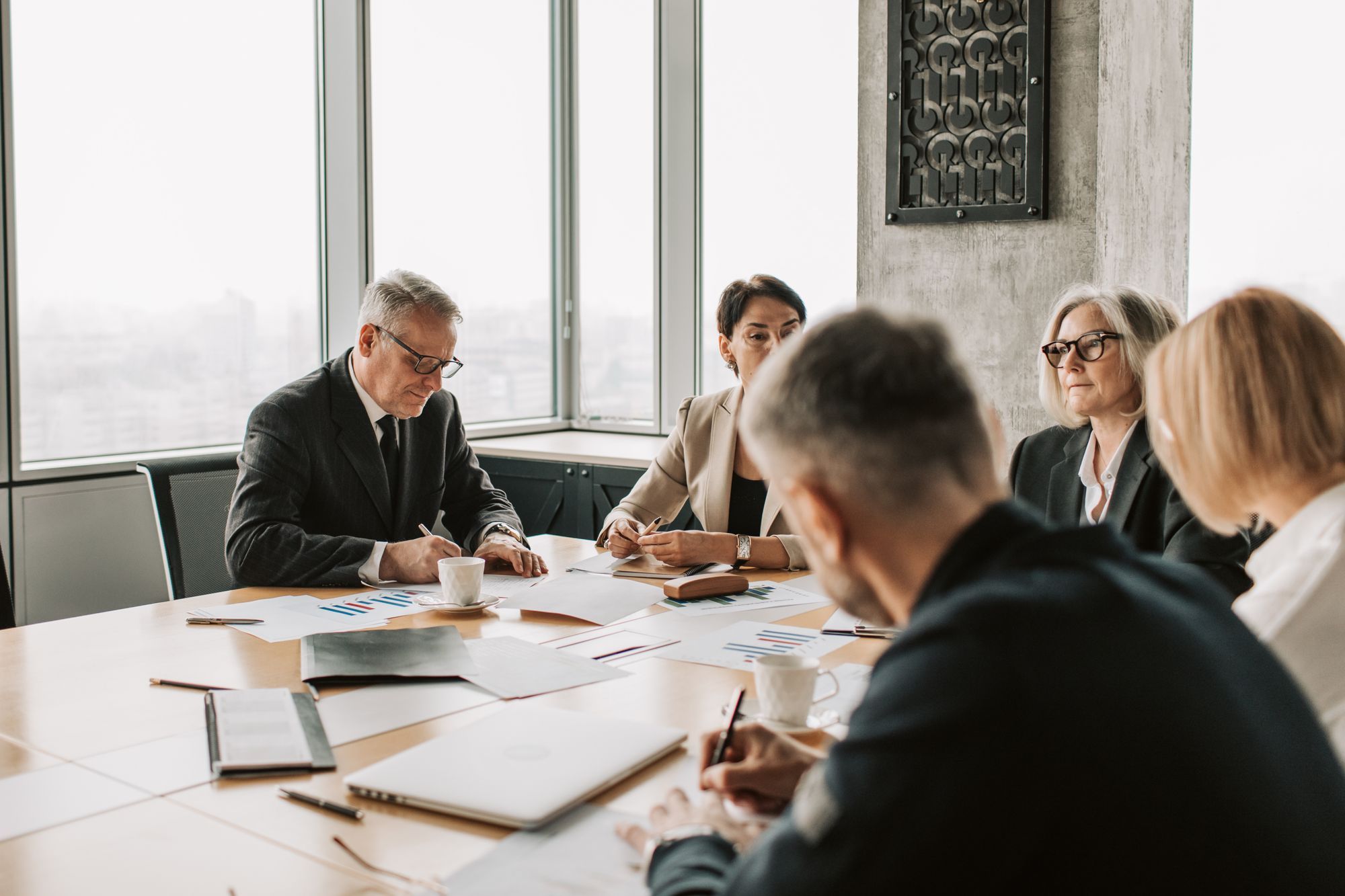 A management team reviewing documents around a meeting table