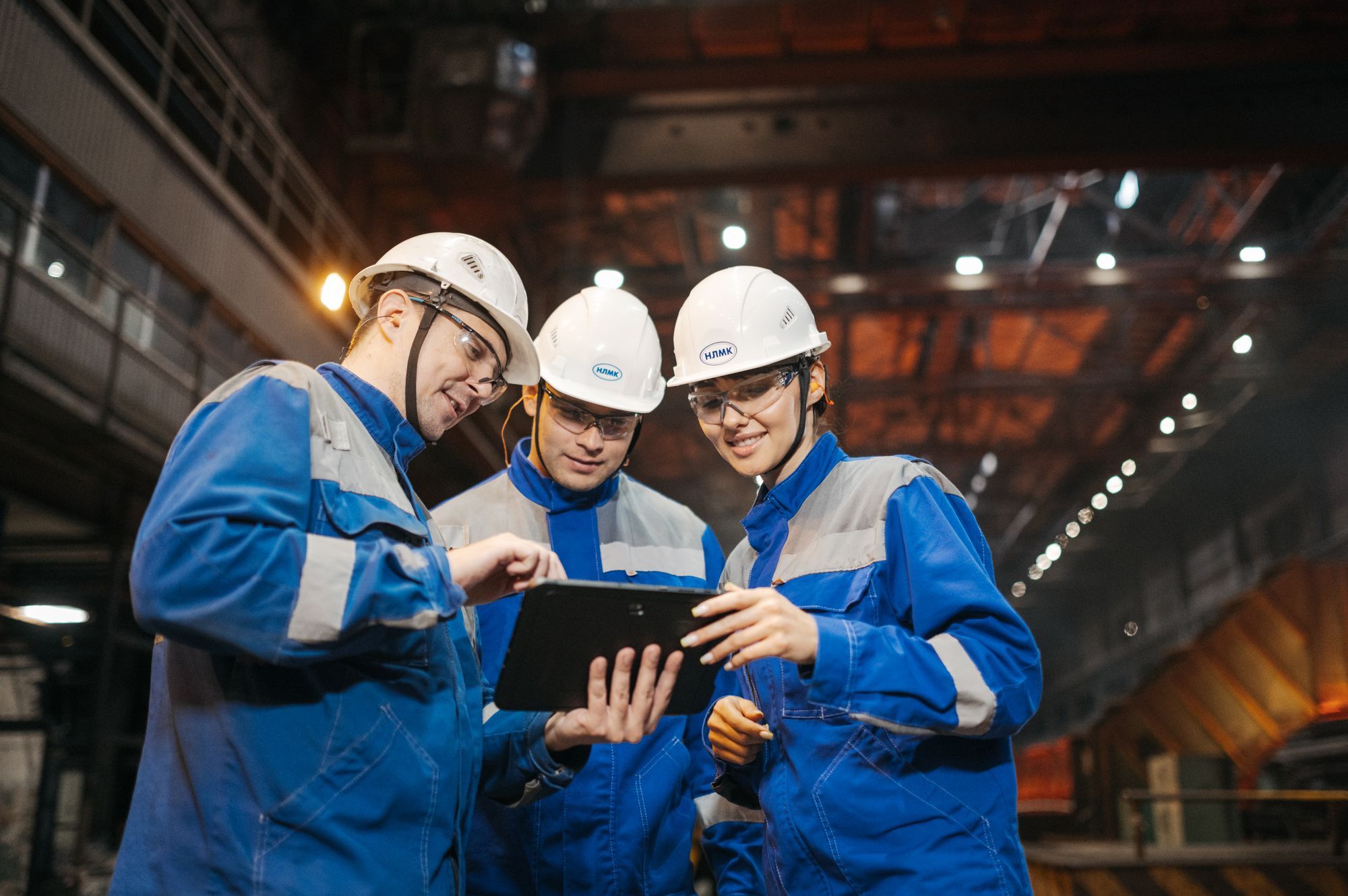 Engineers in a factory reviewing audit findings together on a tablet